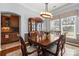 A formal dining room is set with dark wood table, 6 chairs, and elegant china cabinet at 9415 Rosalyn Glen Rd, Cornelius, NC 28031