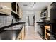 Galley kitchen with black countertops and blue tile backsplash at 1115 Scaleybark Rd # D, Charlotte, NC 28209