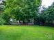 Large backyard with a hot tub, mature trees, and well-maintained grass at 117 Biscayne Ct, Mooresville, NC 28117