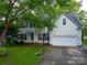 Charming two-story home featuring a well-manicured lawn, a two-car garage, and a basketball hoop for outdoor fun at 117 Biscayne Ct, Mooresville, NC 28117