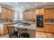 Kitchen boasts light wood cabinets, an island with tile top, and black appliances at 117 Biscayne Ct, Mooresville, NC 28117