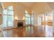 Large living room with hardwood floors, fireplace, and tall windows, seamlessly connecting to the kitchen at 117 Biscayne Ct, Mooresville, NC 28117