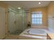 Main bathroom featuring a glass-enclosed shower and soaking tub at 117 Biscayne Ct, Mooresville, NC 28117