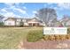 Community clubhouse with a manicured lawn and signage for community amenities: pool, tennis, and fitness facility at 11735 Ridgeway Park Dr, Charlotte, NC 28277