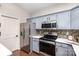 Modern kitchen with gray cabinets, stainless steel appliances, and mosaic backsplash at 11735 Ridgeway Park Dr, Charlotte, NC 28277