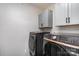 Modern laundry room featuring new Samsung washer and dryer and sleek gray cabinets at 11735 Ridgeway Park Dr, Charlotte, NC 28277