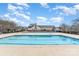 Community pool on a sunny day with lounge seating and a clear blue swimming area with nearby pool house at 11735 Ridgeway Park Dr, Charlotte, NC 28277