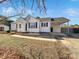 Front view of a charming white house with a covered carport at 1215 Neal Hawkins Rd, Gastonia, NC 28056