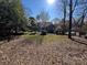 Large backyard with a grassy area and mature trees at 1432 Jules Ct, Charlotte, NC 28226