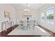 Bright dining room with a glass table, white chairs, wood floors, and lots of natural light at 1527 Sunflower Field Pl, Matthews, NC 28104