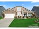 Charming two-story home featuring stone accents, a manicured lawn, and a two-car garage at 1527 Sunflower Field Pl, Matthews, NC 28104