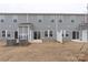 Townhouse rear view, showing grey siding, patios, and AC units at 1608 Village Grove Ln, Monroe, NC 28110