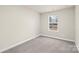 Bright bedroom featuring a window with blinds and grey carpeting at 1608 Village Grove Ln, Monroe, NC 28110