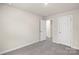 Spacious bedroom with grey carpet and two white doors at 1608 Village Grove Ln, Monroe, NC 28110