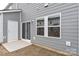 Rear exterior of townhome with grey siding, patio, and sliding glass door at 1608 Village Grove Ln, Monroe, NC 28110