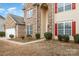 Front entrance of a two-story brick home with red shutters at 16737 Winston Oaks Ct # 297, Charlotte, NC 28213