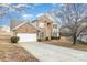 Two-story brick home with a white garage door and driveway at 16737 Winston Oaks Ct # 297, Charlotte, NC 28213