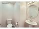 Small bathroom with white sink, toilet, and round mirror at 1750 J Julian Ln, Charlotte, NC 28208