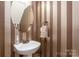 Stylish powder room with vertical striped wallpaper at 20215 Middletown Rd, Cornelius, NC 28031