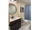 Modern bathroom with white subway tiles, dark vanity, and a round mirror at 206 King Henry Ln, Gastonia, NC 28056