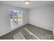 Well-lit bedroom with a window offering a view and wall-to-wall carpet at 2115 Windy Hill Ln, Monroe, NC 28110