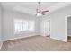 Spacious bedroom featuring a ceiling fan, large window, and neutral carpeting at 2820 Rosemeade Dr, Monroe, NC 28110