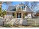 White house with teal front door, arbor, and picket fence at 410 7Th St, Spencer, NC 28159