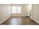 Living room with wood-look flooring and large windows at 4762 Old Lantern Way, Charlotte, NC 28212