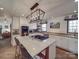 Modern white kitchen with a central island cooktop, quartz countertops, and stainless steel appliances at 5229 Mt Holly Huntersville Rd, Charlotte, NC 28216