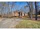 Two-story brick home nestled among mature trees, showcasing a welcoming front entrance at 5424 Amanda Ln, Belmont, NC 28012