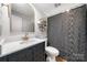 Modern bathroom with dark vanity, gold fixtures, and gray shower curtain at 59 Ridgeport Rd, Clover, SC 29710