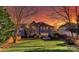 Spacious backyard featuring a lush green lawn, mature trees, and a cozy patio with a lovely sunset at 626 Lorain Nw Ave, Concord, NC 28027