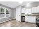 Eat-in kitchen with white cabinets, stainless steel appliances, and wood flooring at 6603 Wandering Creek Dr, Charlotte, NC 28216