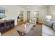 Living room with hardwood floors, featuring a round mirror and a sofa at 6633 Old Reid Rd, Charlotte, NC 28210