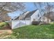 Grassy backyard with a white fence, landscaping, and a view of the home's exterior and trees at 8636 Robinson Forest Dr, Charlotte, NC 28277