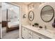 Elegant bathroom with double vanity, framed mirrors, and neutral walls with an open view to bedroom at 8636 Robinson Forest Dr, Charlotte, NC 28277