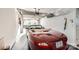 Clean, well-lit garage featuring a red convertible car, storage shelves, and an automatic door opener at 8636 Robinson Forest Dr, Charlotte, NC 28277