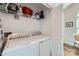 Functional laundry room with a washer, dryer, storage shelves, and a view of a sunlit space at 8636 Robinson Forest Dr, Charlotte, NC 28277