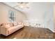 Cozy upstairs living room with a pink couch, hardwood floors, a ceiling fan and bright natural light at 8636 Robinson Forest Dr, Charlotte, NC 28277