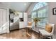 Bright sunroom featuring a large arched window, hardwood floors, and comfortable seating at 8636 Robinson Forest Dr, Charlotte, NC 28277