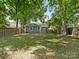 Spacious backyard with lush lawn, mature trees, and a wooden fence at 1317 Downs Ave, Charlotte, NC 28205
