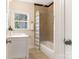 Clean bathroom with a tub shower, white vanity, and window at 1317 Downs Ave, Charlotte, NC 28205