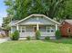 Charming craftsman style home with a gray exterior, front porch, and well-manicured lawn at 1317 Downs Ave, Charlotte, NC 28205