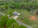 Home on a large lot with lush green lawn, concrete driveway, and surrounded by many mature trees at 1410 Mays Chapel Church Rd, Newton, NC 28658
