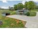 Two-story home with wooden balcony, attached garage, and large concrete driveway in a rural setting at 1410 Mays Chapel Church Rd, Newton, NC 28658