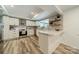 Bright kitchen features white cabinets, stainless steel appliances, laminate floors, and open-concept design at 1410 Mays Chapel Church Rd, Newton, NC 28658