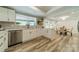 Modern kitchen with laminate floors, quartz countertops, white cabinetry, and stainless steel dishwasher at 1410 Mays Chapel Church Rd, Newton, NC 28658