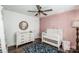 Bedroom with crib, dresser, and pink accent wall at 148 Tarrington Dr, Statesville, NC 28625