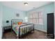Bedroom with light teal walls and a metal bed frame at 1733-C Matheson Ave, Charlotte, NC 28205