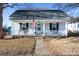 White house with gray roof, porch and American flag at 298 Misenheimer Nw Dr, Concord, NC 28025